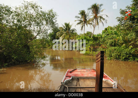 Cruising along a tributary of the Mekong River near Vinh Long, Mekong Delta, Vietnam. Stock Photo