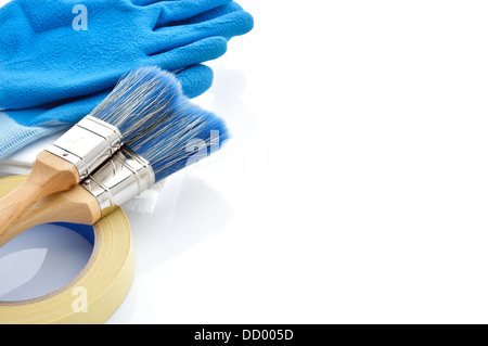 Painting tools on white background. Masking tape, brushes, drop cloth and gloves on white background. Plenty of copy space. Stock Photo