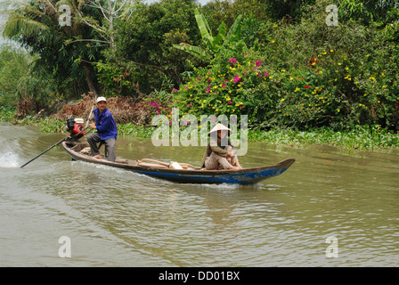 Man and woman travelling along the Mekong River on a small motorboat. Vinh Long, Mekong Delta, Vietnam. Stock Photo