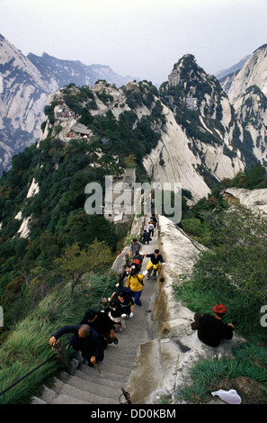 Chinese pilgrims and hikers making the ascent in Hua Shan mountain located near the city of Huayin in Shaanxi province China. Mount Hua is the western mountain of the Five Great Mountains of China, and has a long history of religious significance. Stock Photo