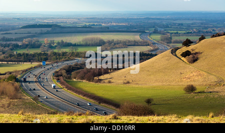 The M40 Junction 6 looking north west snaking through the Aston Rowant Cutting (or Stokenchurch Gap), mirrored in the hill path. Stock Photo