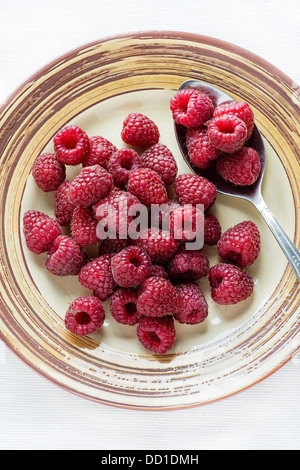 Light Overhead A Raspberry Raspberries on a red background in a flower design Stock Photo - Alamy