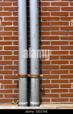 drainpipe on a wall with bricks Stock Photo