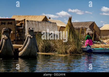 Lake Titicaca: islands of Uros with family on reed island, reed huts and prows of reed boats visible, Peru