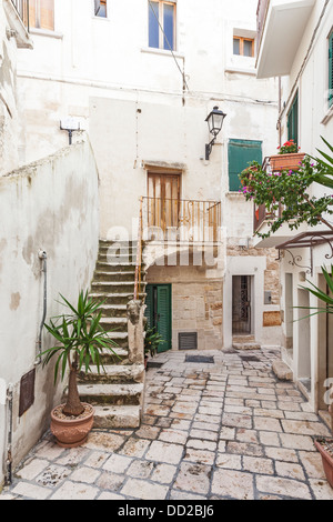 Narrow paved alleyway with steps and paving stones in the charming historic old town of Polignano a Mare, Apulia, southern Italy Stock Photo