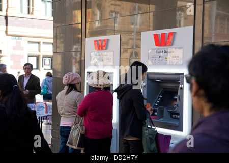 Two asian ladies withdrawing cash from a Westpac bank branch ATM in ...