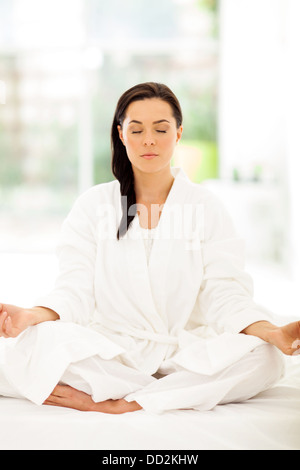 beautiful young woman meditating in bedroom Stock Photo