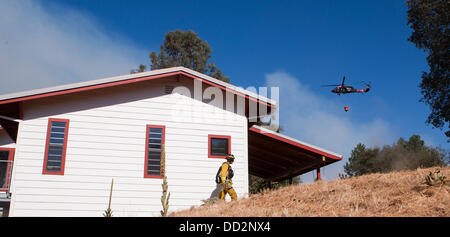 Buck Meadows, CA, USA. 23rd Aug, 2013. A National Guard Black Hawk flies over a home on Clements Rd near Pine Mountain Lake CA as fire approaches. The Rim Fire in the Stanislaus National Forest along Highway 120 continues to grow. According to the US Forest Service as of Friday Aug. 23rd 2013 afternoon the fire has grown to 125,620 acres with only 5% containment with more evacuations in Tuolumne City, CA and nearby areas along the Highway 108 corridor. The fire continues to spread in several directions including towards Yosemite National Park. Credit:  Marty Bicek/ZUMAPRESS.com/Alamy Live News Stock Photo