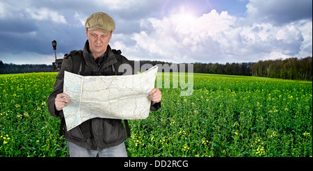 Photographer hiker with map against fields and nature Stock Photo