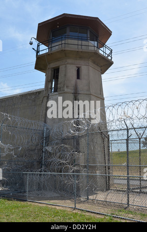 American maximum security prison guard tower and perimeter wall. Tower officers are armed with rifles and shotguns. Stock Photo