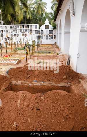 Cemetery in Goa, India with a freshly dug hole for burial Stock Photo