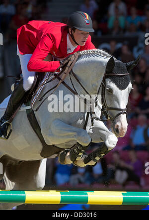 Herning, Denmark. 24th Aug, 2013. German show jumper Daniel Deusser jumps over a hurdle on his horse Cornet D'Amour in the first round of the single final during the FEI European Championships in jumping and dressage in Herning, Denmark, 24 August 2013. Photo: Jochen Luebke/dpa/Alamy Live News Stock Photo