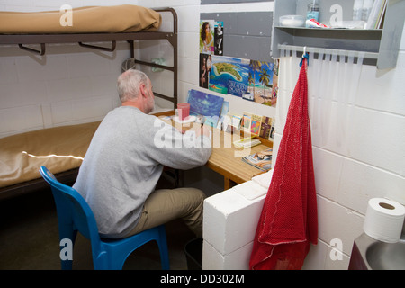 Inmate alone in cell writing a letter. Work release, minimum security prison, Lincoln, Nebraska, USA. Stock Photo