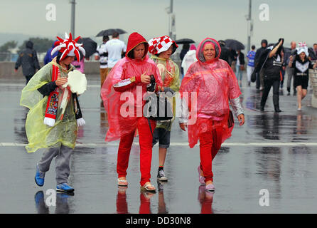 London, UK. 24th Aug, 2013. Wigan Supporters struggle through the rain before the start of the Rugby League Challenge Cup Final between Hull FC and Wigan Warriors from Wembley Stadium Credit:  Action Plus Sports/Alamy Live News Stock Photo