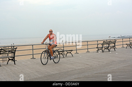 A man exercises on his bicycle on the Biegelman Boardwalk in Brighton Beach Brooklyn, New York. Stock Photo