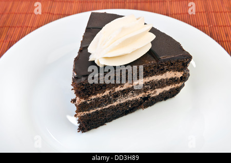 Piece of chocolate cake on white plate at table Stock Photo