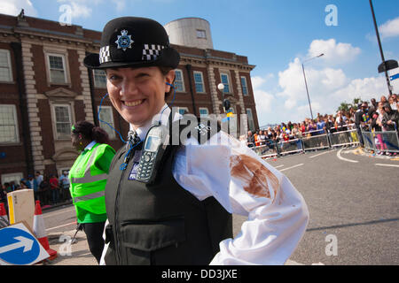 London, UK. 25th Aug, 2013. A police officer shows evidence of having come too close to chocolate smeared revellers as the annual two-day Notting Hill Carnival celebrating Afro-Carribean culture and London's ethnic diversity gets underway. Credit:  Paul Davey/Alamy Live News Stock Photo