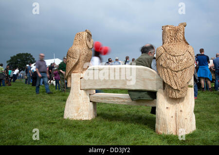 Cheshire Game & Country Fair, UK,  Aug 24 to Aug 26, 2013.  Chainsaw carved Owls; art figures at the 6th Tabley Cheshire Game & Country Fair held the Showground, Tabley, Knutsford, Cheshire, UK.  An event that attracts hundreds of exhibitors, prestigious championships & competitions and visitors from throughout the United Kingdom. Wood sculpture, sawdust, sculptor, timber, chips, log, professional, working, art, artist, cut, chain saw, artwork made from rough timber log. Stock Photo