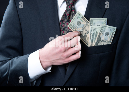 Concept photo showing businessman with money in pocket pulling out twenty dollar bill Stock Photo