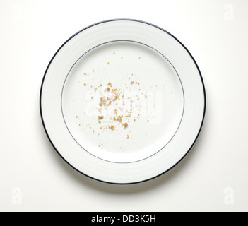 A round plate with only crumbs remaining. Stock Photo