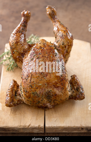 Whole roast chicken on wooden table overlook