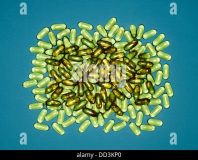 A large group of green capsule pills on a blue background Stock Photo