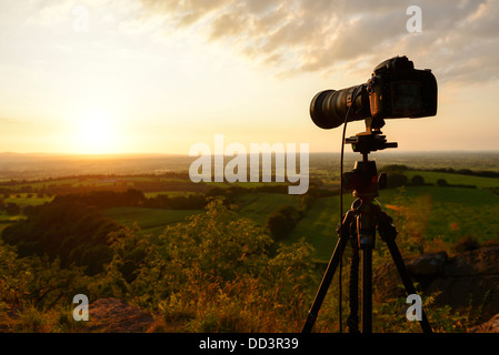 Nikon D800 camera and tripod taking a sunset landscape photograph looking over the Cheshire Plain UK Stock Photo