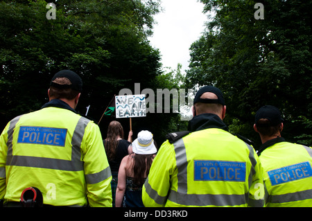 Balcombe protest against fracking. A man holds a placard saying 'We are earth' in front of a line of police. Stock Photo