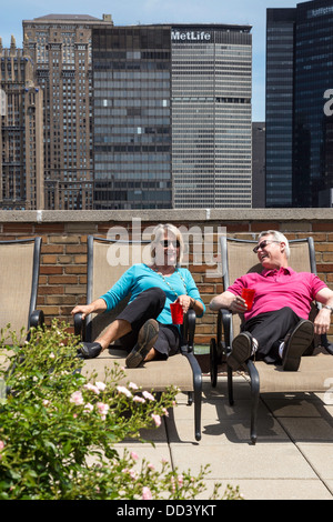 Attractive Mature Couple Relaxing on Roof Deck, NYC Stock Photo