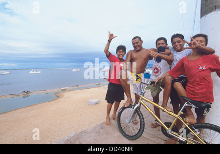 Friendly young men wave at visitors on the waterfront at Santarem, Brazil Stock Photo