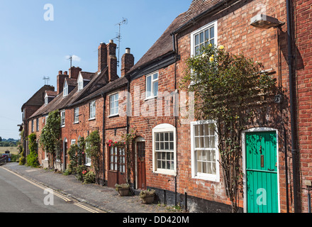 Row of traditional brick built terraced cottages in Tewkesbury, Gloucestershire, England, in summer with a blue sky Stock Photo