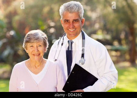 happy middle aged doctor and senior patient outdoors Stock Photo