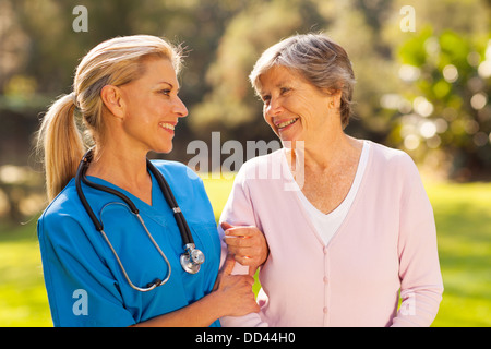 caring nurse talking to senior woman outdoors Stock Photo