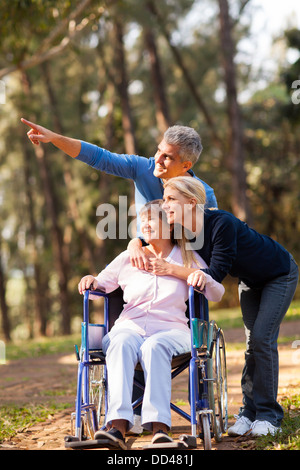 loving mid age couple taking senior mother for a walk outdoors Stock Photo