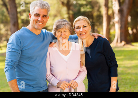 loving mid age couple and senior mother outdoors in forest Stock Photo