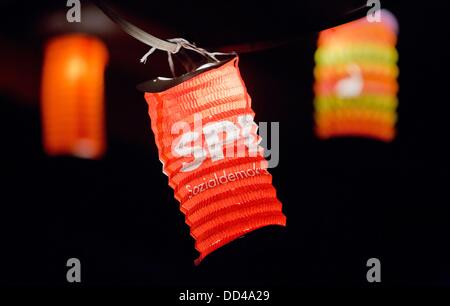 A single red lantern with the logo of the German Social Democratic Party (SPD) hangs amid other lanterns on a string of lights at a campaign event of the Hamburg SPD candidate Hakverdi at a summer feast on the fruit farm Jonas in Neuenfelde in the south of Hamburg, Germany, 09 August 2013. Germany holds general elections on 22 September 2013. Photo: Christian Charisius Stock Photo