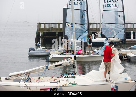 An amputee sailor prepares the sails on a sonar racing dinghy before racing begins for a disabled sailboat regatta in Newport RI Stock Photo