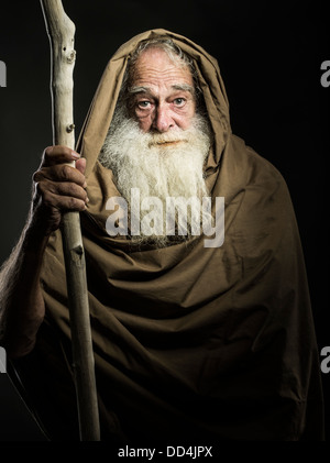 old man with white beard staff and cloak looks like wizard  / Gandalf / Moses / Dumbledore Stock Photo