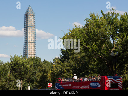 Open top sightseeing tour bus in front of Washington Monument (currently in scaffolding), Washington DC, USA Stock Photo
