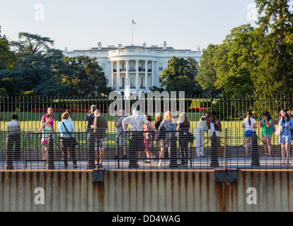 Crowds look at South Lawn view of White House Washington DC by fence and security barriers Stock Photo