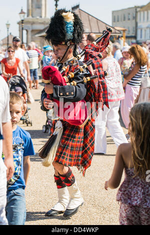 Kent, UK - August  26th, 2013: A man in full Scottish highland costume entertains the bank holiday crowds on the seafont in Henre Bay kent. Credit:  CBCK-Christine/Alamy Live News Stock Photo