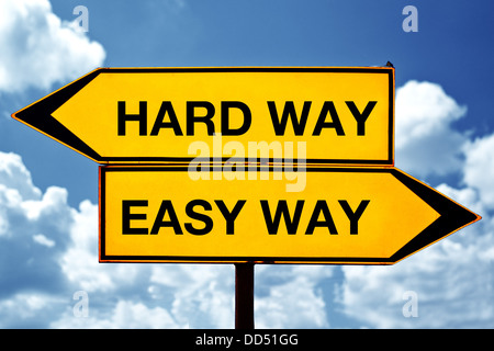 Hard way or easy way, opposite signs. Two opposite signs against blue sky background. Stock Photo