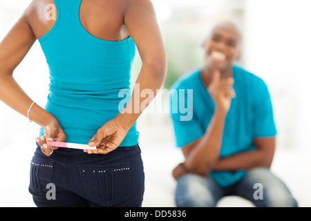woman hiding positive pregnancy test from her spouse for a surprise Stock Photo