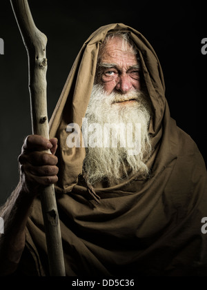 old man with white beard staff and cloak looks like wizard  / Gandalf / Moses / Dumbledore Stock Photo