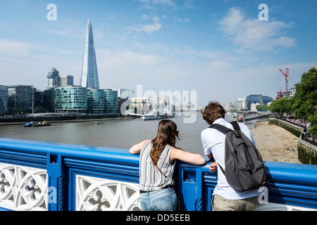 A couple standing on Tower Bridge looking at the Thames. Stock Photo