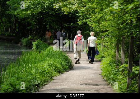 An elderly senior couple walking along the Cromford canal Derbyshire uk Stock Photo