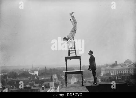 Jammie Reynolds, balancing on the on chairs on the edge of a rooftop in Washington, DC ca. 1921 Stock Photo