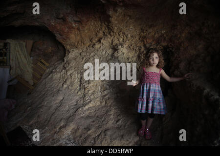 Silwan, Jerusalem, Palestinian Territory. 26th Aug, 2013. The daughter of Khaled al-Zeer al-Husaini, 39, stands at her father's cave in the east Jerusalem Arab neighbourhood of Silwan, August 26, 2013. Al-Husaini is a father of five children live in a cave, which was a stable for animals, after Israeli authorities demolished his own home 3 days ago under the pretext of building without permits Credit:  Saeed Qaq/APA Images/ZUMAPRESS.com/Alamy Live News Stock Photo