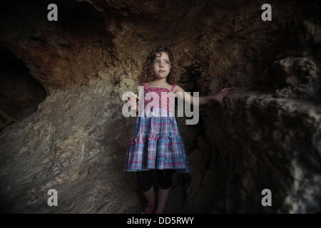 Silwan, Jerusalem, Palestinian Territory. 26th Aug, 2013. The daughter of Khaled al-Zeer al-Husaini, 39, stands at her father's cave in the east Jerusalem Arab neighbourhood of Silwan, August 26, 2013. Al-Husaini is a father of five children live in a cave, which was a stable for animals, after Israeli authorities demolished his own home 3 days ago under the pretext of building without permits Credit:  Saeed Qaq/APA Images/ZUMAPRESS.com/Alamy Live News Stock Photo