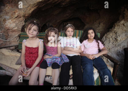 Silwan, Jerusalem, Palestinian Territory. 26th Aug, 2013. Daughters of Khaled al-Zeer al-Husaini, 39, sit at their father's cave in the east Jerusalem Arab neighbourhood of Silwan, August 26, 2013. Al-Husaini is a father of five children live in a cave, which was a stable for animals, after Israeli authorities demolished his own home 3 days ago under the pretext of building without permits Credit:  Saeed Qaq/APA Images/ZUMAPRESS.com/Alamy Live News Stock Photo